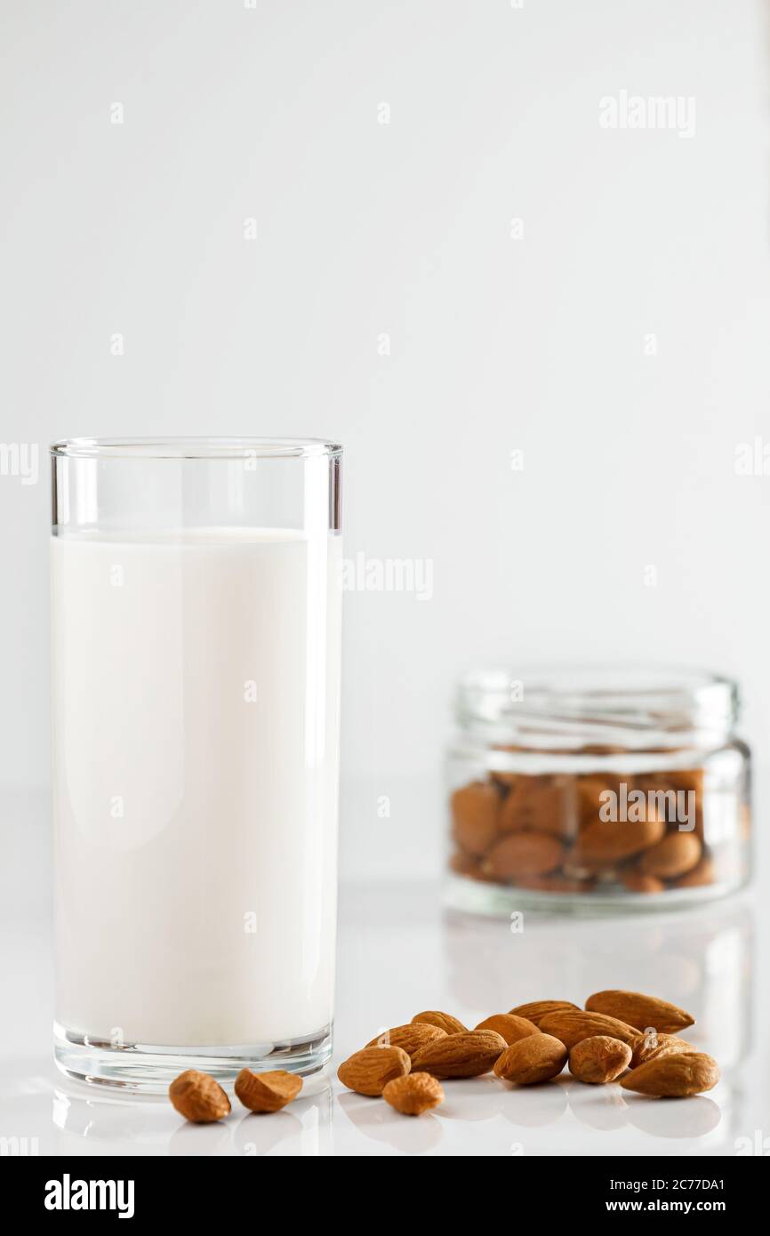 Ein Glas Mandelmilch auf weißem Hintergrund. Laktosefreie pflanzliche Ernährung Milch. Glutenfreies Mandelgetränk auf blauem Hintergrund. Super Essen - EIN Glas Stockfoto