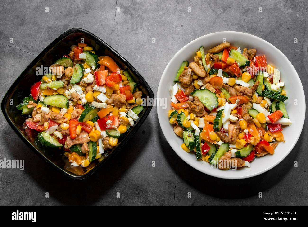 Zwei Schüsseln mit Gemüsesalat für die richtige Ernährung auf grauem Hintergrund Stockfoto