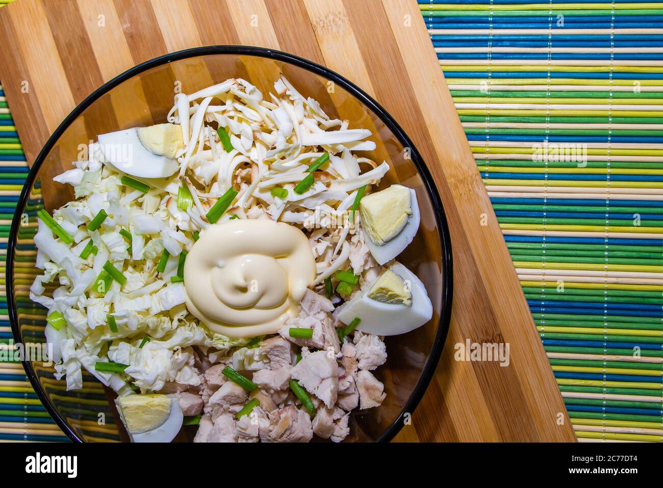 Diätetischer Salat für die richtige Ernährung mit Huhn und Eiern auf einer grünen Matte. Stockfoto