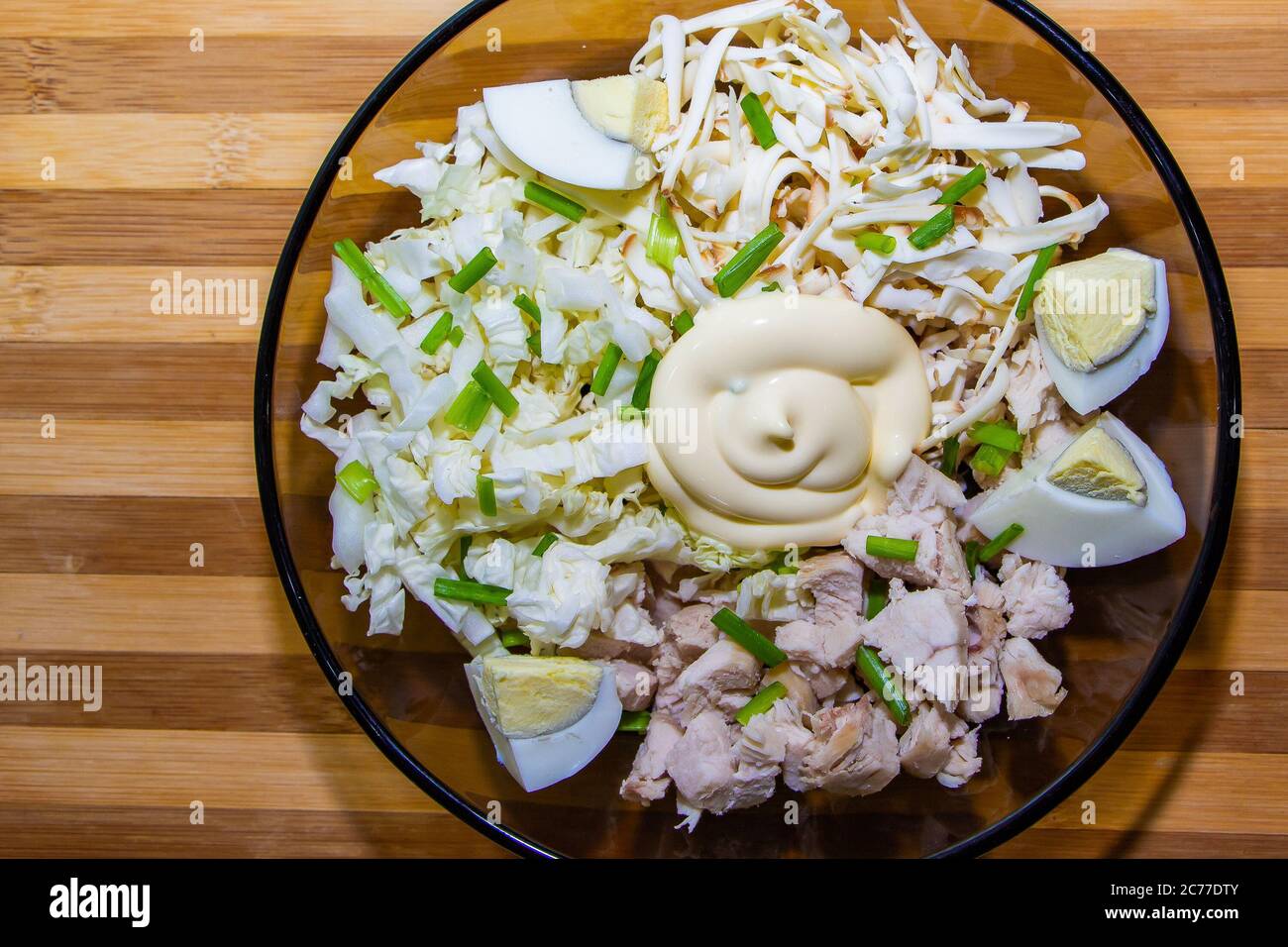 Diätetischer Salat für die richtige Ernährung mit Huhn und Eiern auf einer grünen Matte. Stockfoto