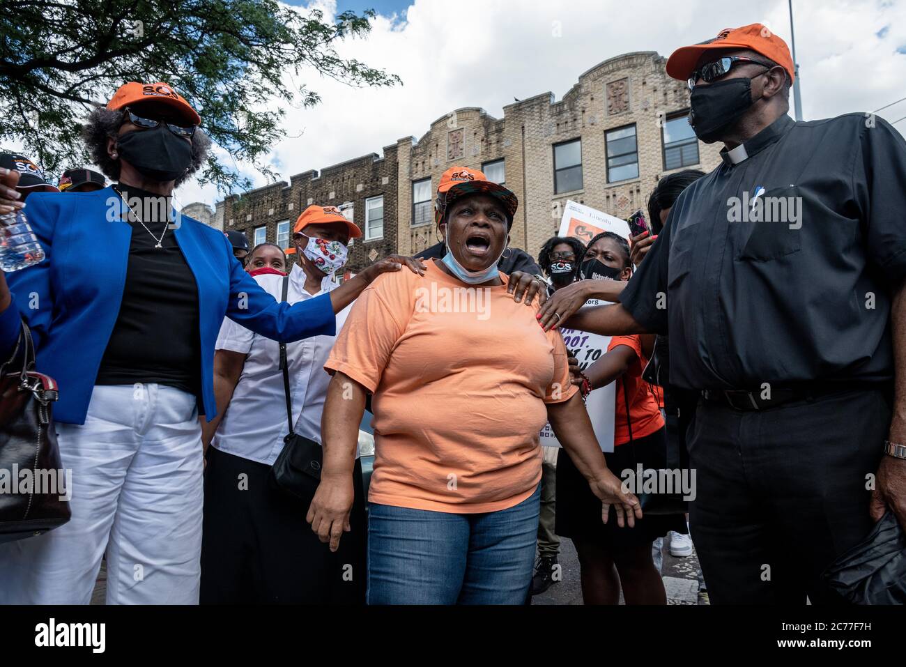 Brooklyn, Vereinigte Staaten Von Amerika . Juli 2020. Mitglieder des Klerus trösten und beten für eine Mutter, die ihren Sohn durch Waffengewalt beim S.O.S. marsch gegen Gewalt und für Frieden im Crown Heights Viertel von Brooklyn am 14. Juli 2020 verloren hat. Die Kundgebung war eine Reaktion auf eine Zunahme von Schießereien und Tötungen, darunter ein einjähriges Baby am Wochenende. (Foto von Gabriele Holtermann/Sipa USA) Quelle: SIPA USA/Alamy Live News Stockfoto
