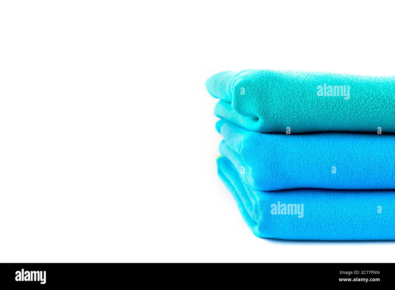 Nahaufnahme Half Stack Handtücher grün und blau auf weißem Hintergrund mit Kopierplatz. Stockfoto