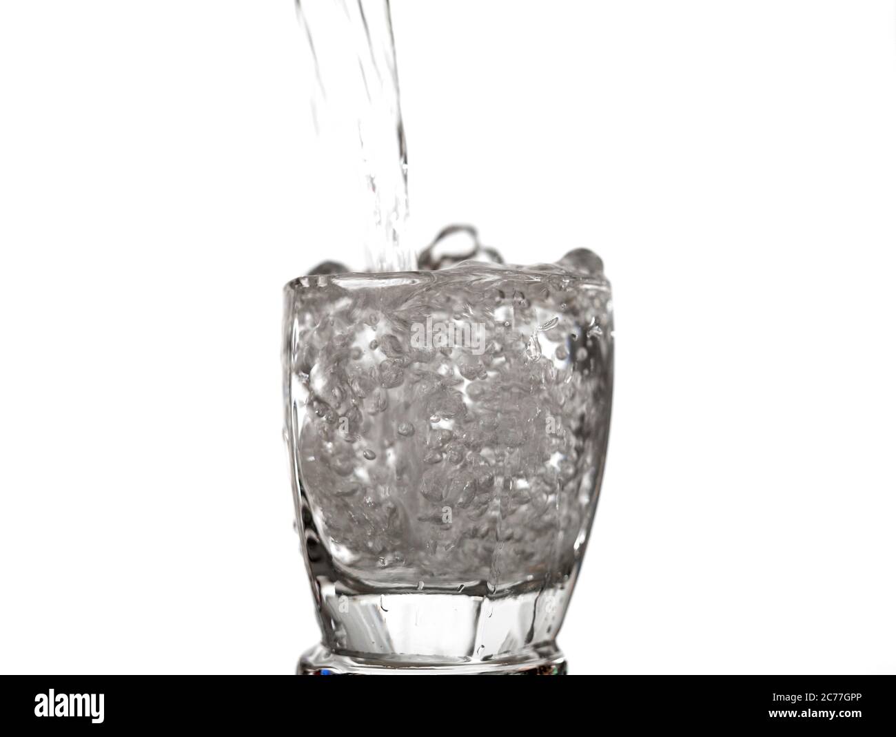 Wasser spritzt zu Glasüberlauf isoliert auf weißem Hintergrund Stockfoto