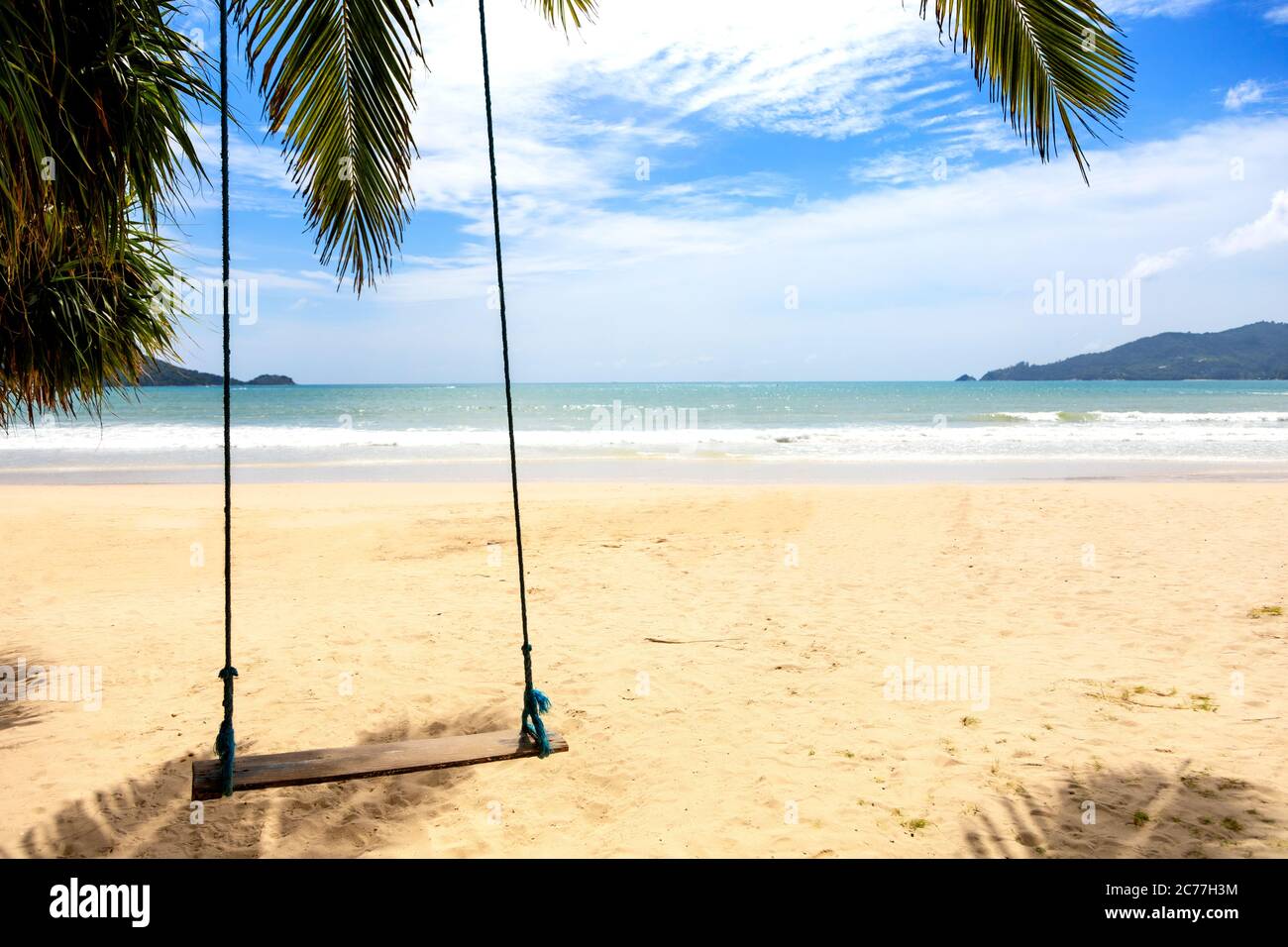 Sommerkonzept. Holzschaukel, der von Kokospalme über dem Strandmeer hängt. Asien Thailand. Mit Platz für Text oder Design Stockfoto