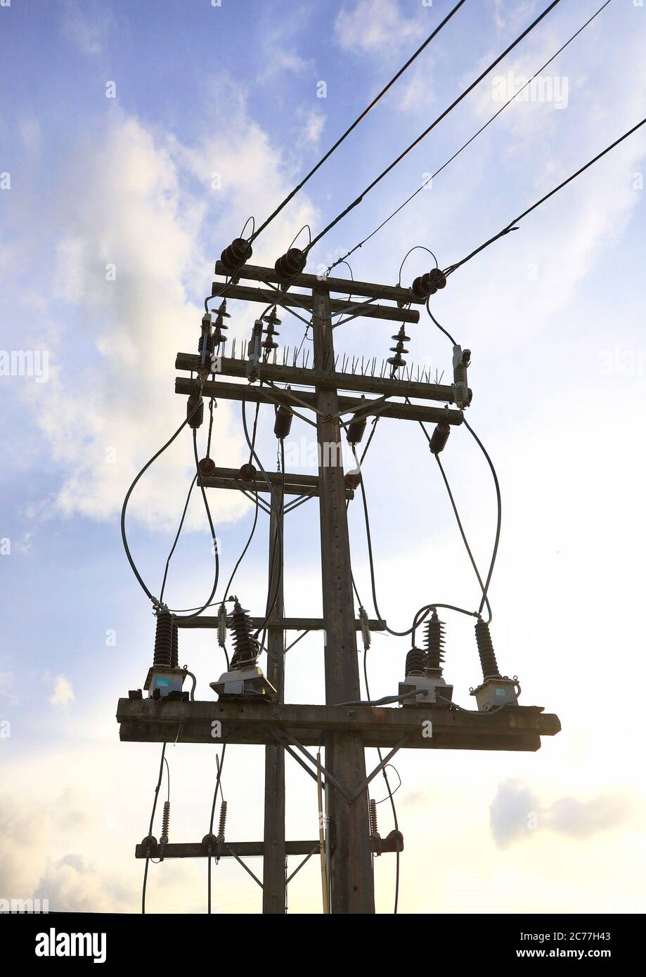 Energie- und Technologiekonzept. Hochspannungs-Strompol mit elektrischer Leitung und kleinen Transformatoren Stockfoto