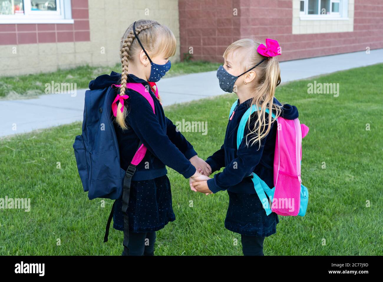 Sicherheit zurück zur Schule Konzept, Tragen von Maske für Schüler. Zwei junge Schwestern gehen zur Schule. Freundschaft, Familie. Stockfoto