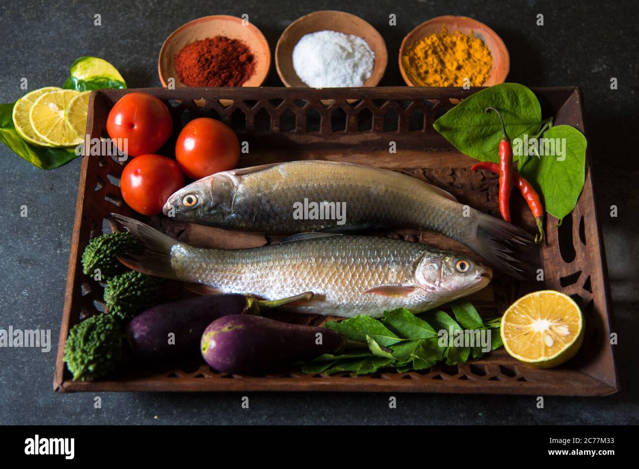 Frischer Fisch und Gemüse mit selektivem Fokus auf einen bestimmten Teil des Fisches und Rest der Fische, Gemüse und andere Zutaten verschwommen. Stockfoto