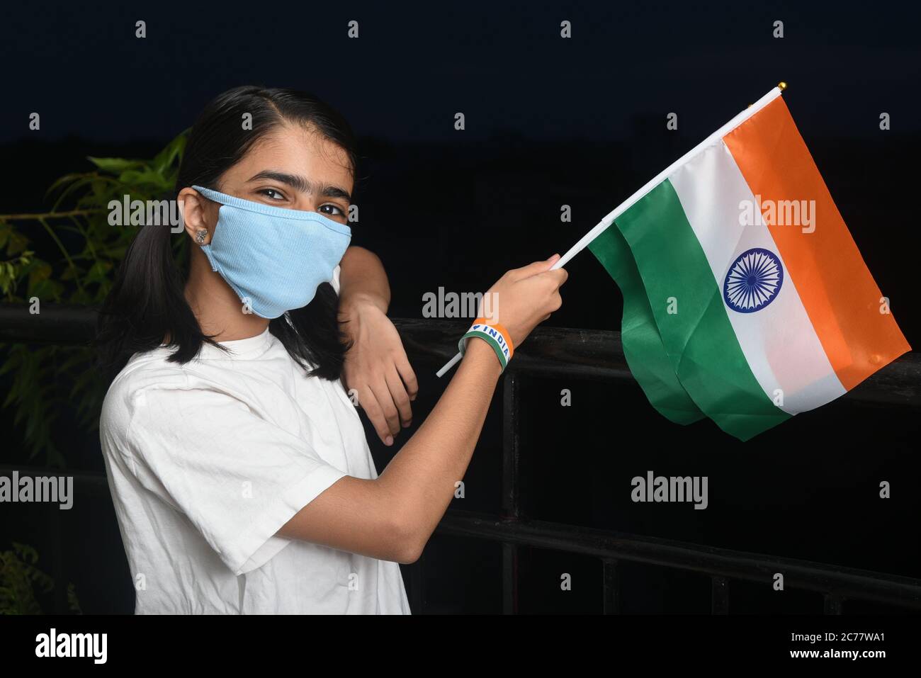 Kerala, Indien. 13. Juli 2020.Corona-Virus-Pandemie oder COVID-19 in Indien. Junges Mädchen hält indische Flagge trägt Sicherheitsmaske. Stockfoto