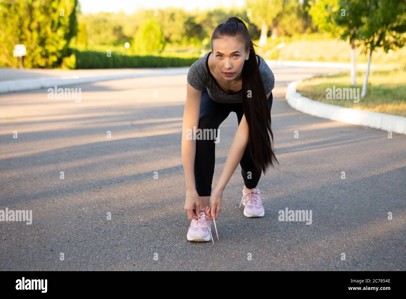 Frau Athlet Läufer Krawatte Schnürsenkel und Blick in die Kamera. Stockfoto