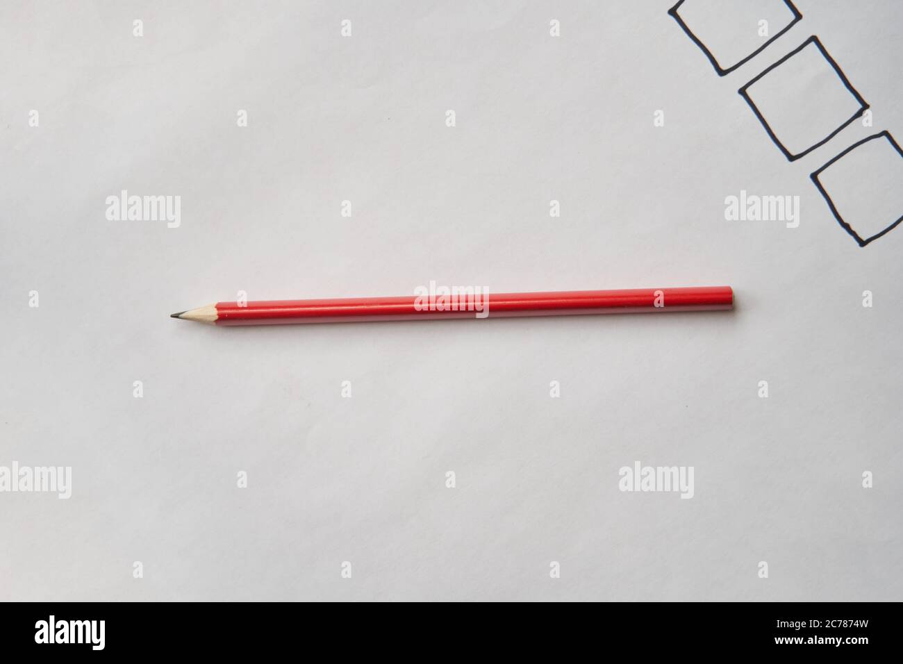 Roter Bleistift liegt auf einem weißen Papier. Stockfoto