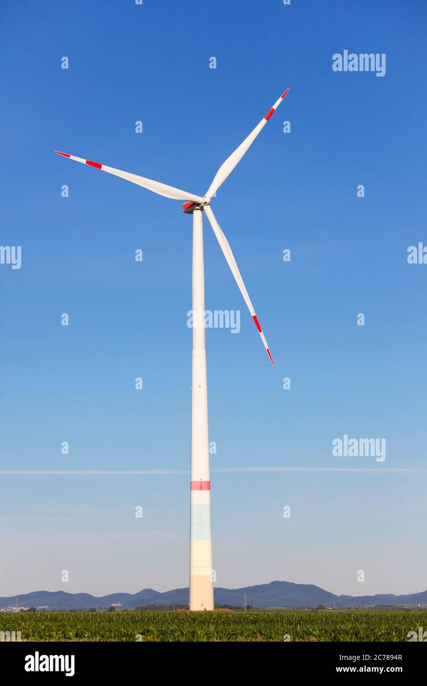 Windmühle vor einer Landschaft mit Hügeln, die grünen Strom produzieren - blauer Himmel Stockfoto