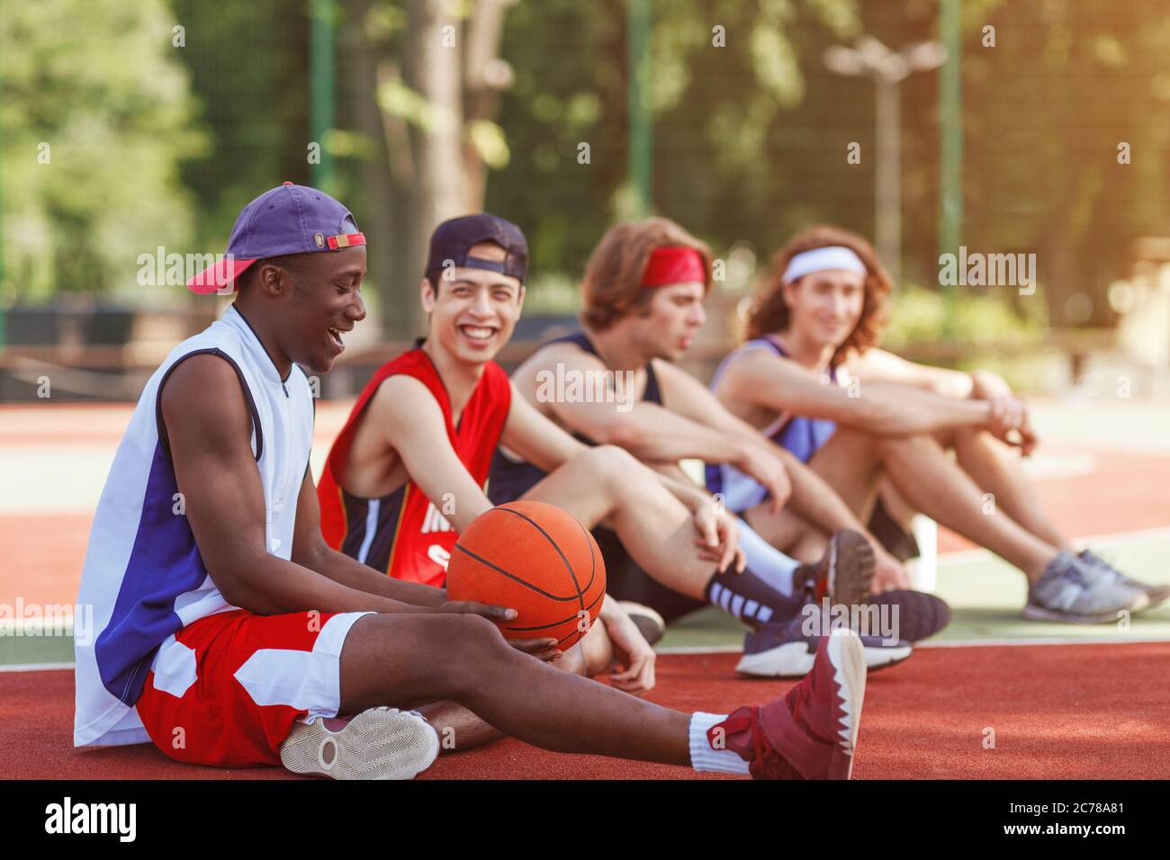 Diverse Profisportler, die nach dem Basketballspiel auf dem Platz im Freien Pause machen, Platz zum Kopieren Stockfoto