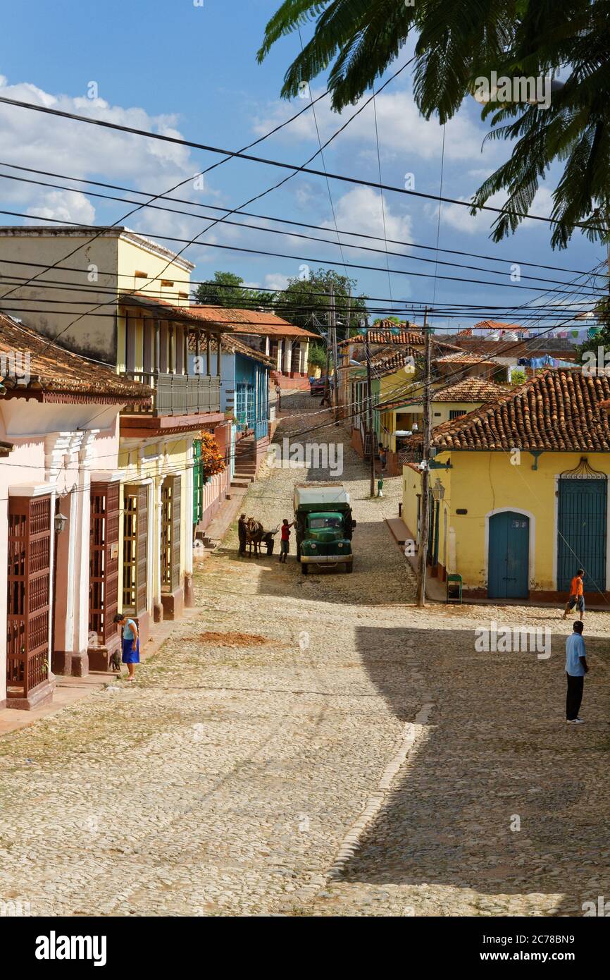 Trinidad Kuba-Nov 23,2013, bunte Straße in Trinidad mit Stromkabeln ein alter LKW und ein Eselskarren und Menschen, die an einem warmen sonnigen Tag vorbei gehen Stockfoto