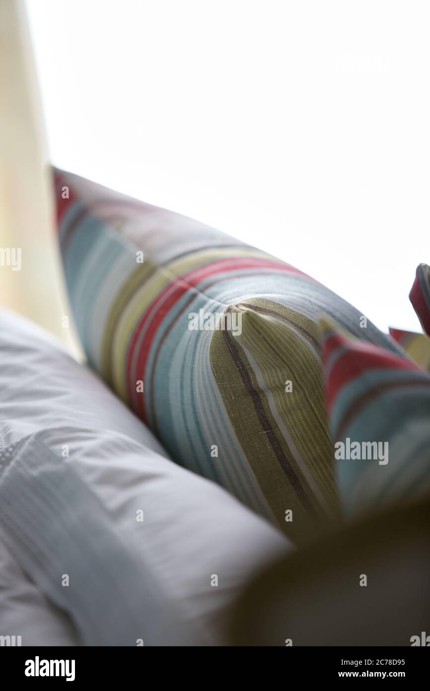 Nahaufnahme von Kissen mit bunten Streifenmustern auf einem Sofa im Wohnzimmer Stockfoto