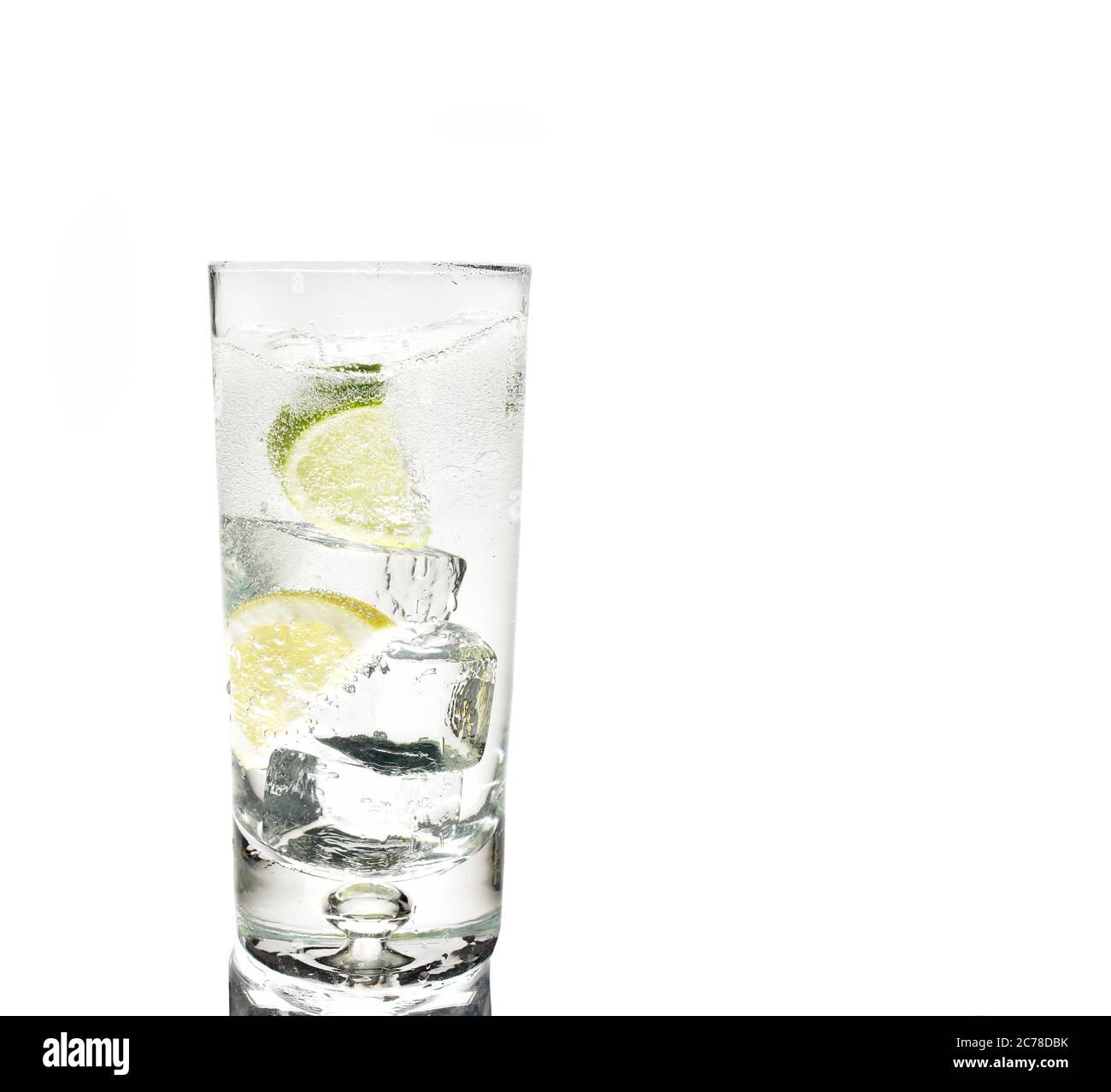 Aufnahme eines Glases Gin Tonic mit Eis und Limette auf weißem Hintergrund mit Kopierraum Stockfoto