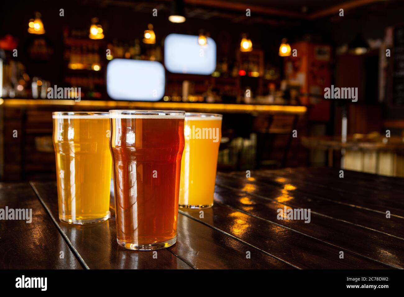 Entspannen Sie sich mit Freunden. Dunkles, helles, ungefiltertes Bier in großen Gläsern auf Holztisch Stockfoto