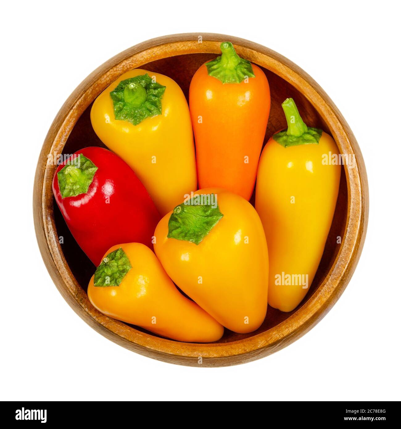 Bunte Paprika in Holzschüssel. Auch Paprika oder Paprika. Frische gelbe, orange und rote Früchte von Capsicum annuum. Stockfoto