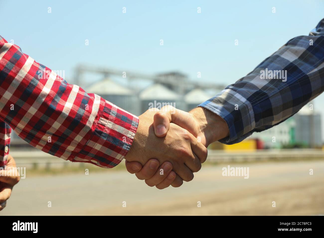 Geschäftsleute schütteln die Hände gegen Silos. Agrarwirtschaft Stockfoto