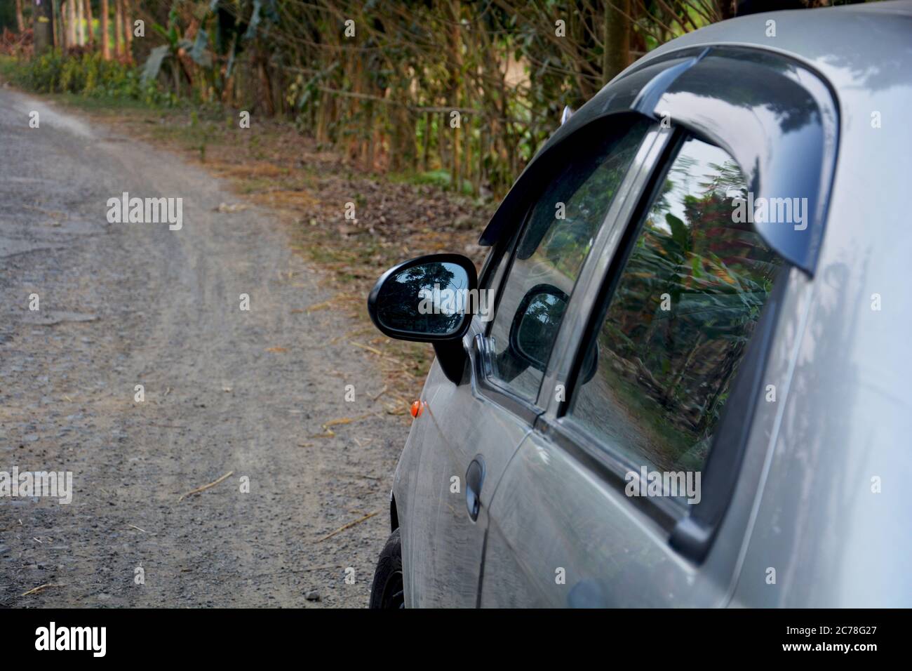 Nahaufnahme der rechten Seite eines Autos mit Seitenspiegel und Fenstern, die auf einer leeren Straße geparkt sind, selektive Fokussierung Stockfoto