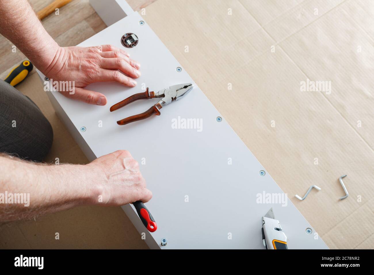 Möbelmontage. Männliche Hände Meister sammelt Möbel mit Schraubendreher-Werkzeuge, Instrument zu Hause. Umzug, Wohnverbesserung, Möbelreparatur und Stockfoto