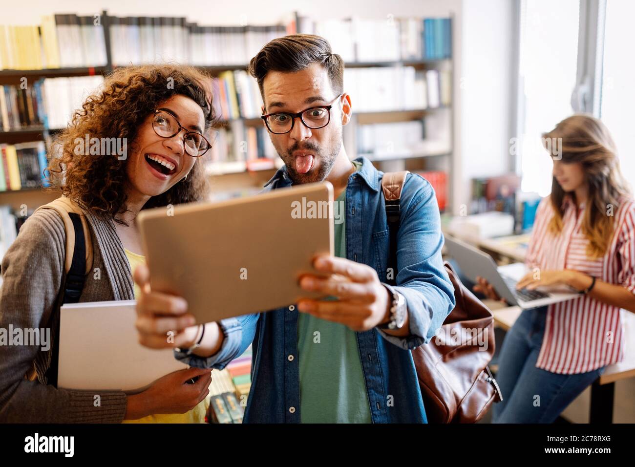 Menschen-, Bildungs- und Schulkonzept. Glückliche Studenten bereiten sich auf Prüfungen in der Bibliothek vor Stockfoto