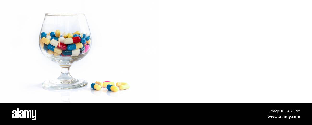 Bunte Pillen und Medikamente in einem Glas auf weißem Panorama-Hintergrund, Gesundheit und Medikamente Konzept Stockfoto