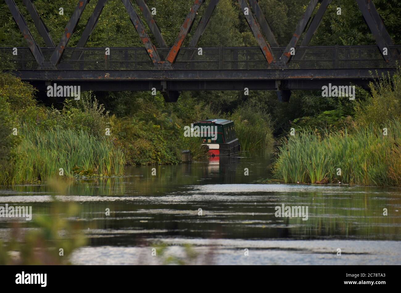 Ein Boot, das in der Ferne auf diesem Foto auf dem schönen Basingstoke Canal in Hampshire ruhte Stockfoto