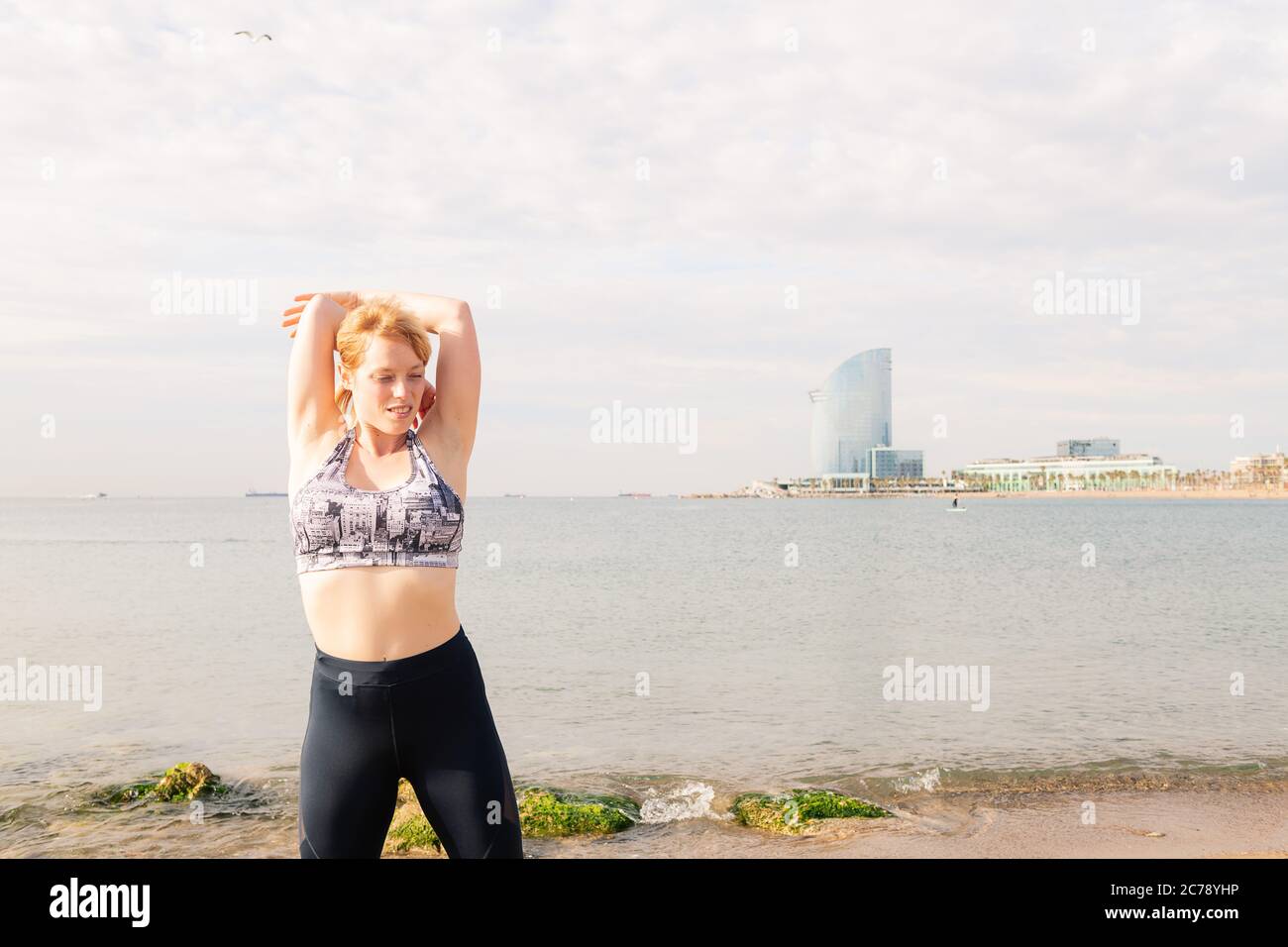 Schöne sportliche Frau, die sich vor dem Meer in der Stadt, gesunden Lebensstil und Sport-Konzept, Copy Space for Text Stockfoto
