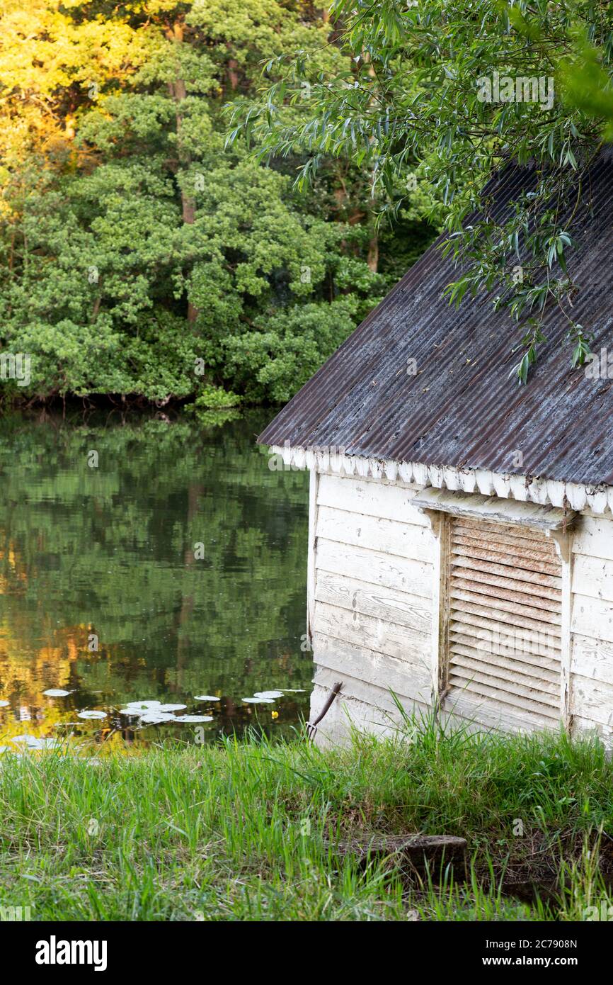 Altes Bootshaus auf dem Wasser bei Sonnenuntergang; Oxfordshire England Großbritannien; Konzept friedlich ruhig Ruhe Ruhe Stockfoto