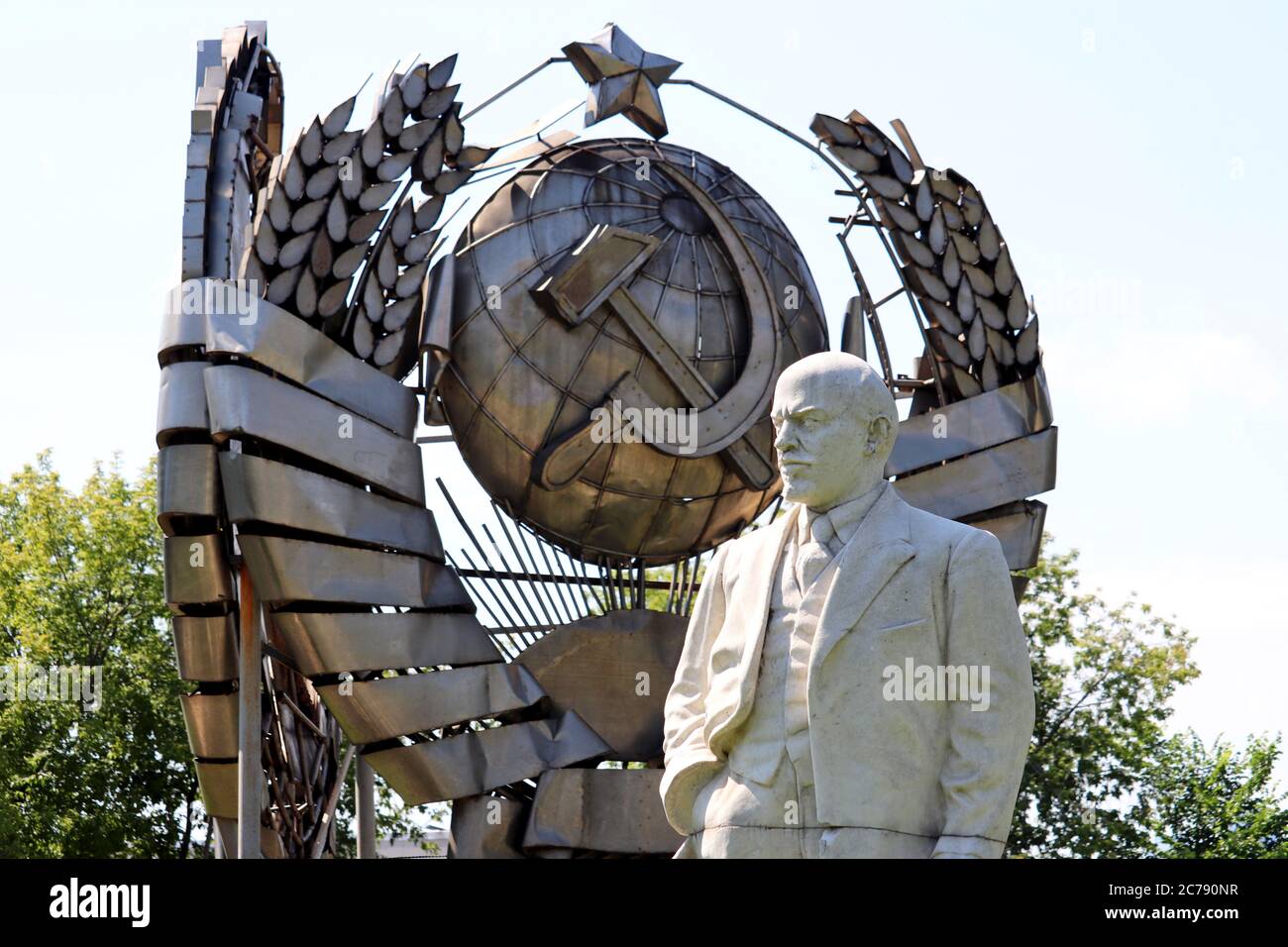 Das Denkmal Lenin, dem Führer des russischen Proletariats gegen das Wappen der UdSSR im Sommerpark Stockfoto