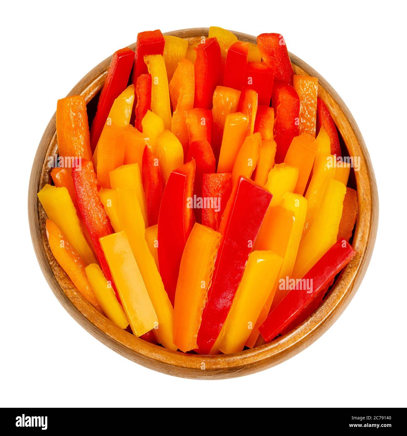 Paprika in Scheiben in einer Holzschüssel. Paprika, Paprika oder auch Paprika genannt, in bunten Streifen geschnitten. Frische gelbe, orange und rote Früchte. Stockfoto
