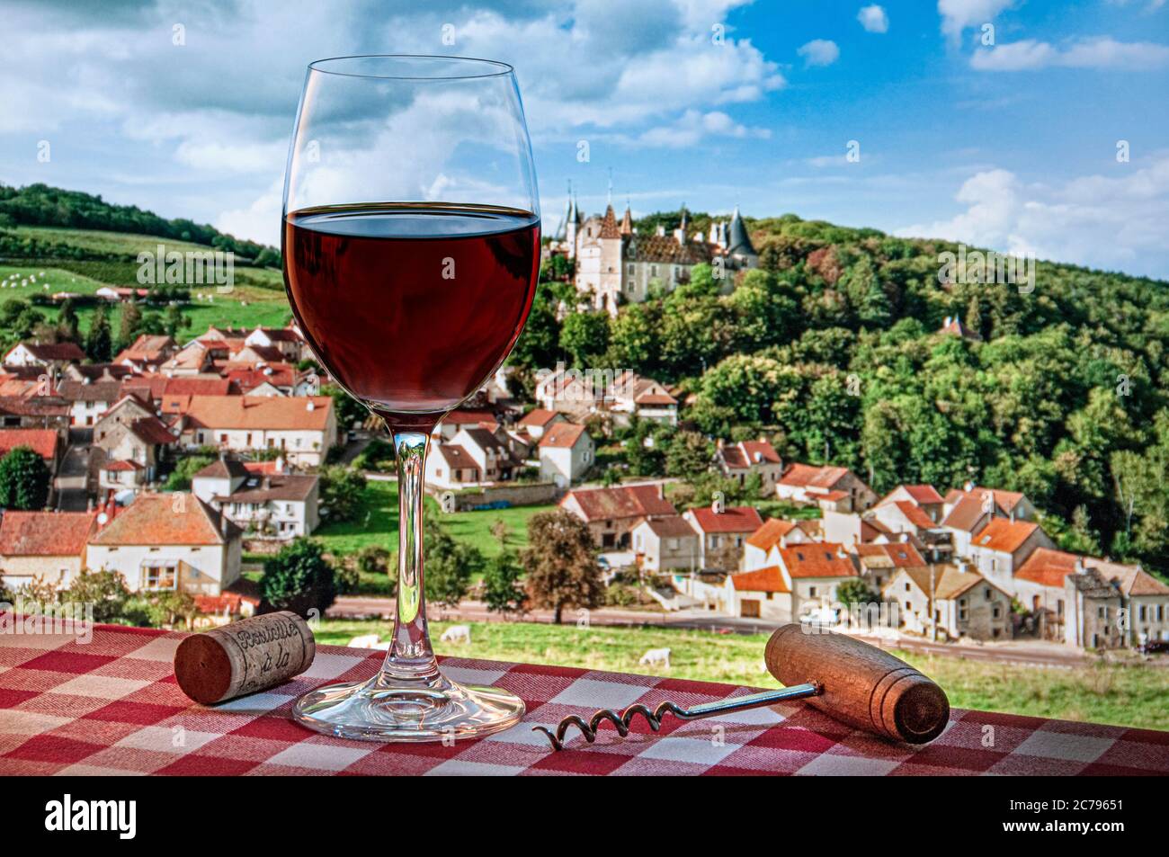 Rotwein im Freien trinken Verkostung Picknick Korkenzieher typisch französisch karierte Tischdecke, mit Dorf & Chateau de la Rochepot hinter Burgund Frankreich Stockfoto