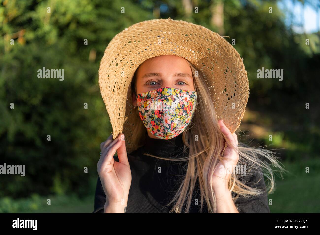 Schöne junge Frau trägt eine stilvolle modische Coronavirus Gesichtsmaske während Covid-19 Pandemie Lockdown Stockfoto