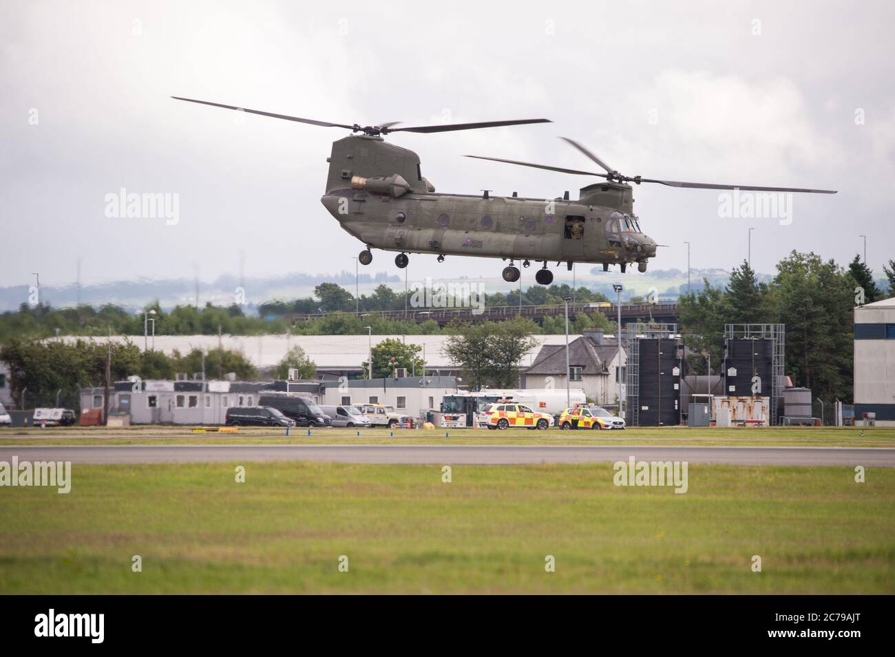 Glasgow, Schottland, Großbritannien. Juli 2020. Im Bild: Royal Air Force Chinook Helicopters auf dem Asphalt und beim Start vom Glasgow International Airport. Einer der Hubschrauber war ‘technisch' mit einem Motorproblem gegangen und ein Ersatzteil wurde von einem anderen Chinook Flugzeug eingeflogen. Viele Menschen und Plane Spotter wurden um den Umzäunungszaun herum gesehen, um die Chopper beim Start zu beobachten. Quelle: Colin Fisher/Alamy Live News Stockfoto