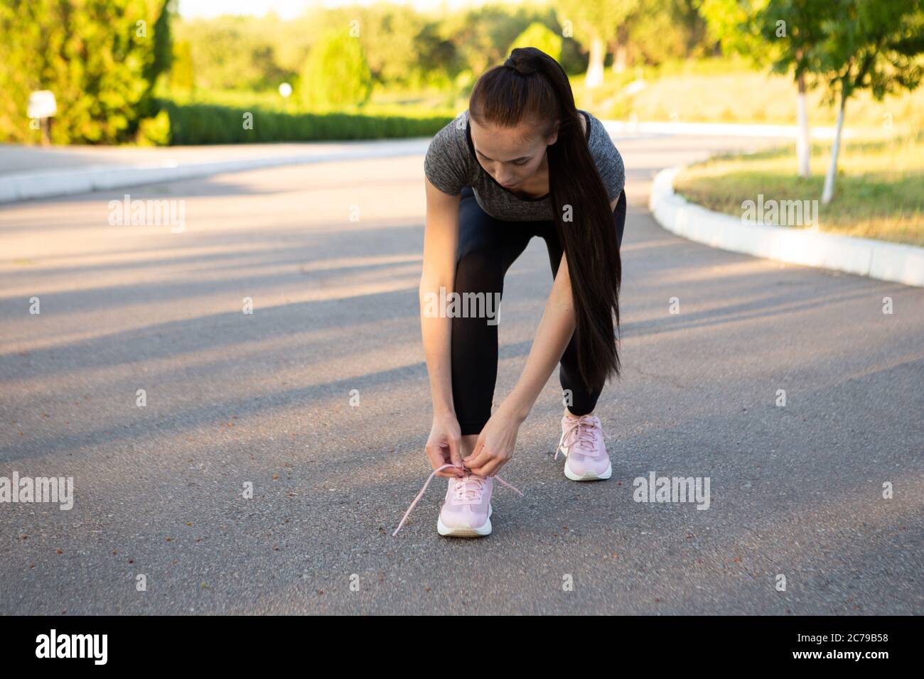 Frau Athletinnen Läuferin binden ihre Schnürsenkel im Sommer vor dem Lauf. Stockfoto