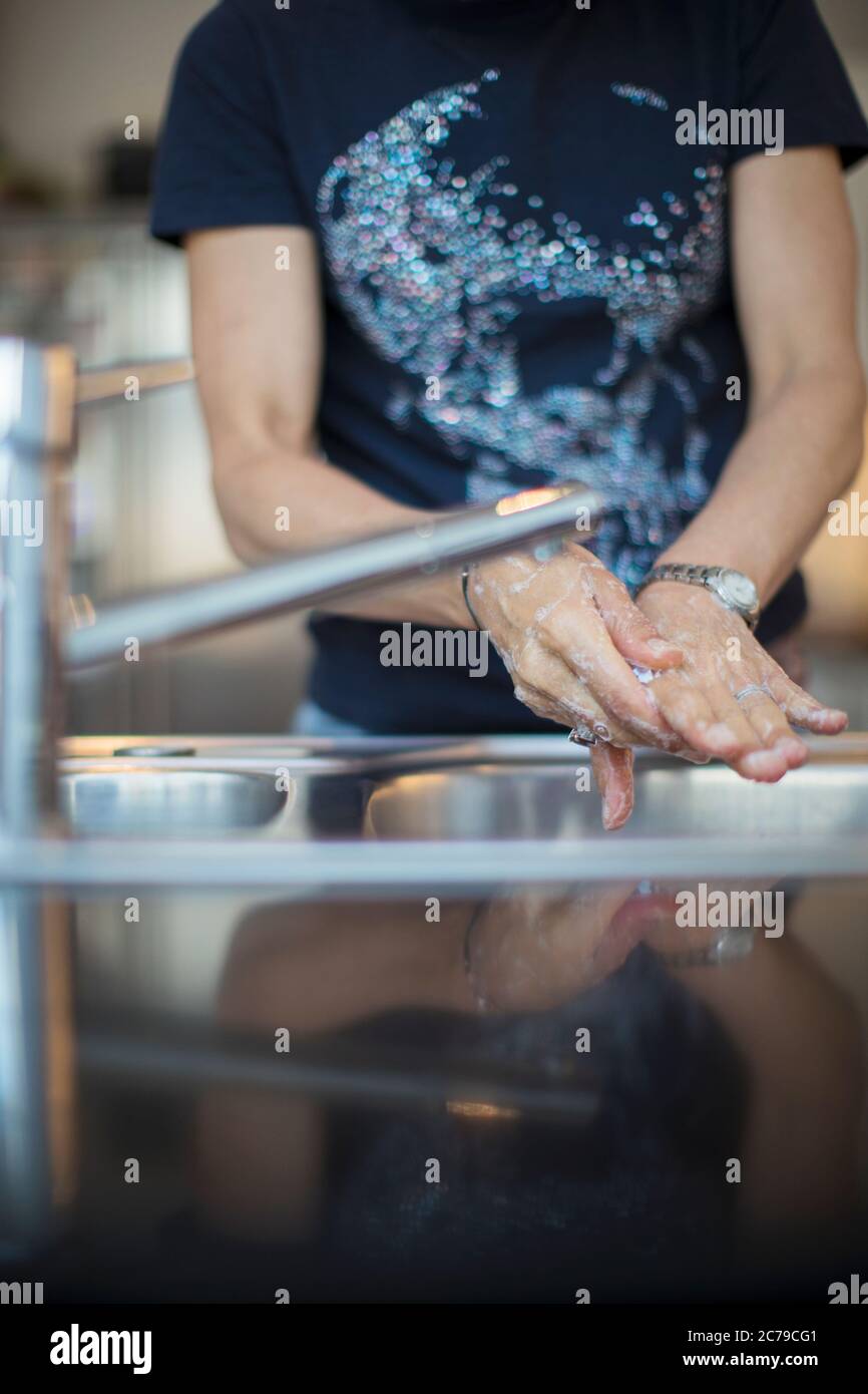 Frau Waschen der Hände am Waschbecken Stockfoto