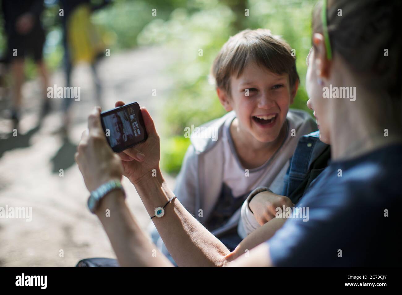 Glückliche Mutter und Söhne Video-Chat mit Freunden auf dem Smartphone Stockfoto