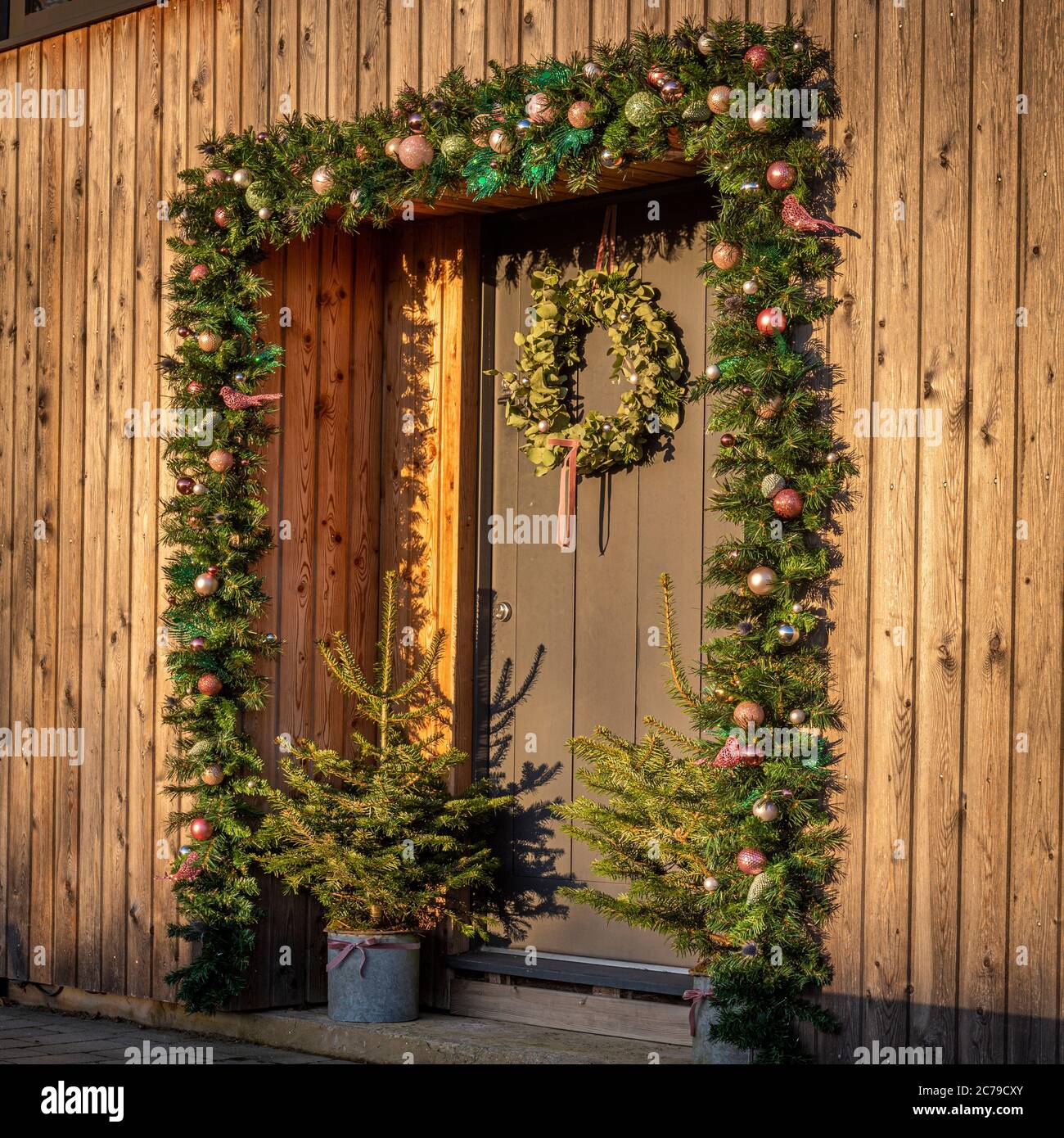 Festliche Dekoration um die Tür auf modernen Holzhaus. Stockfoto