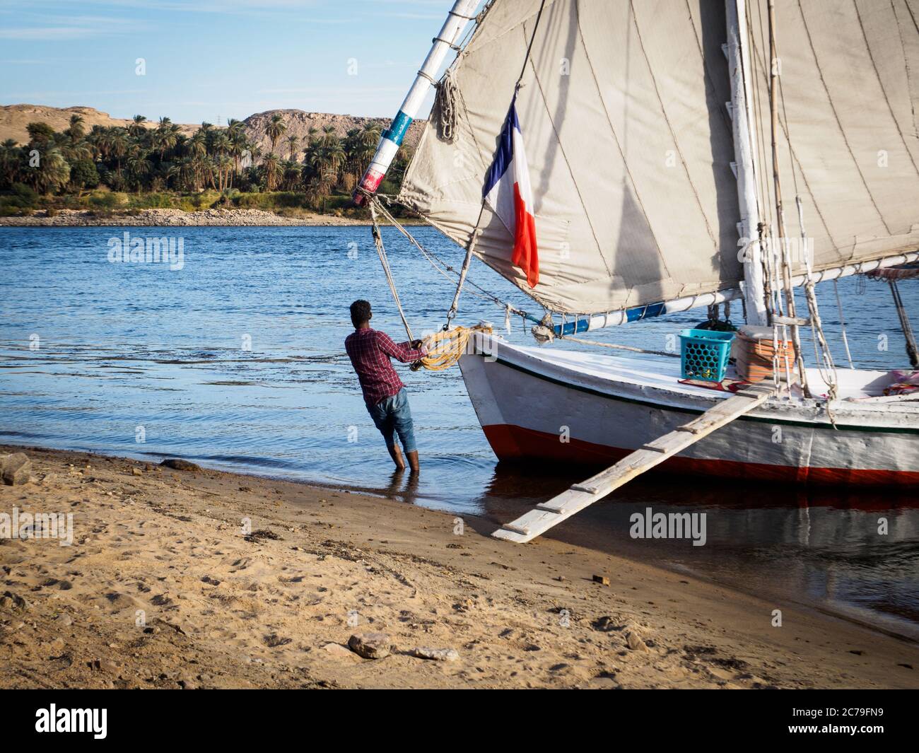 Ein Seemann bringt die Feluca an Land auf dem nil in ägypten Stockfoto