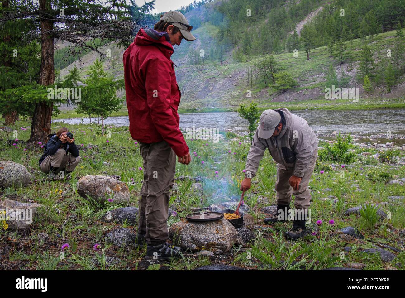 Angelführer kochen Mittagessen am Fluss während einer Angeltour in der Mongolei, Moron, Mongolei - 14. Juli 2014 Stockfoto