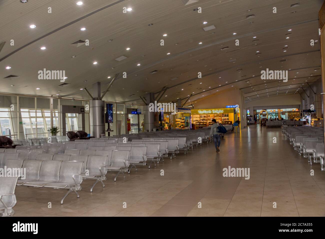 Ein Passagier geht durch ein leeres internationales Flughafenterminal und zeigt die Auswirkungen von Covid 19 auf Flüge, da die Flughäfen wieder geöffnet werden, fliegen Menschen nach Hause. Stockfoto