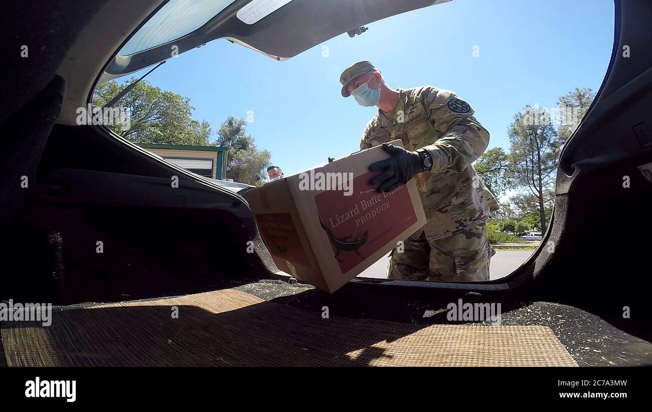 Soldaten der kalifornischen Nationalgarde laden Lebensmittelkartons, um Familien als Reaktion auf COVID-19, eine Coronavirus-Pandemie, bei der Interfaith Food Bank am 26. Juni 2020 in Jackson, Kalifornien, zu helfen. Stockfoto