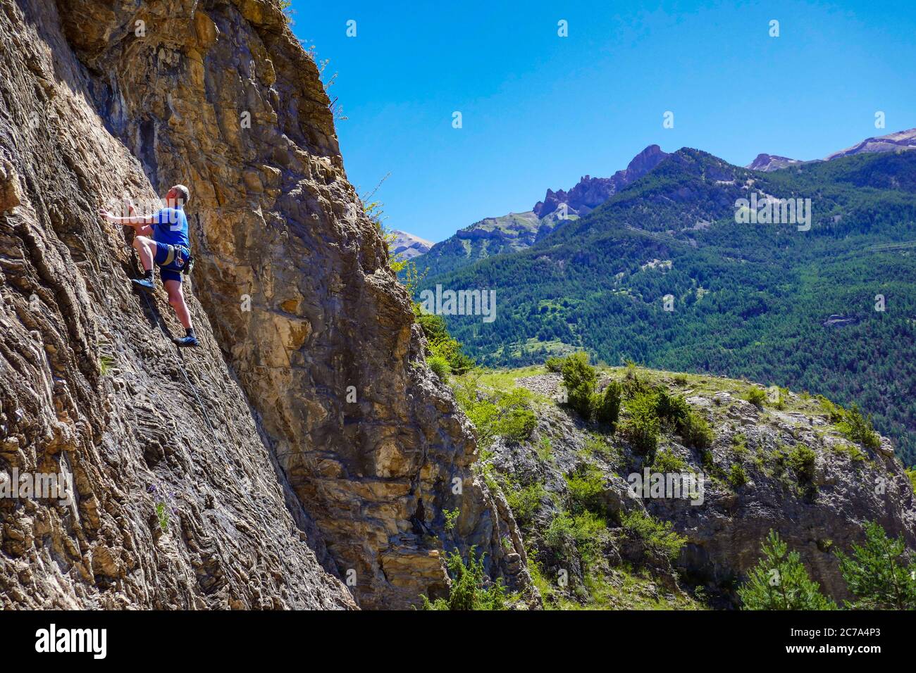 Reifer männlicher Bergsteiger auf einer Klippe im Ecrins Nationalpark, in der Nähe von Briançon, Frankreich Stockfoto