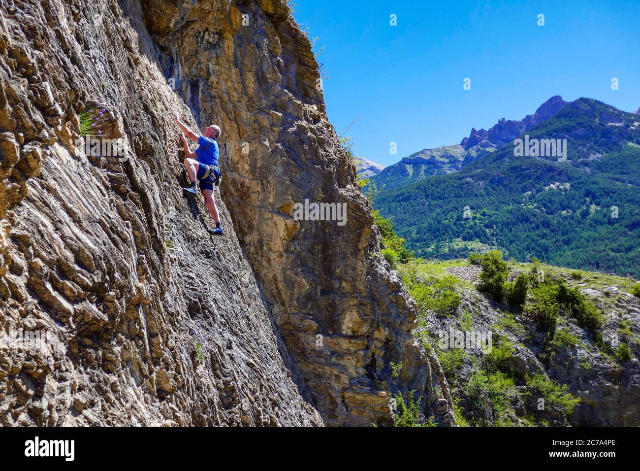 Reifer männlicher Bergsteiger auf einer Klippe im Ecrins Nationalpark, in der Nähe von Briançon, Frankreich Stockfoto