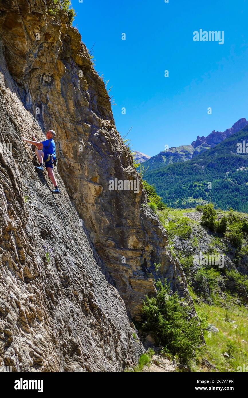 Reifer männlicher Bergsteiger auf einer Klippe im Ecrins Nationalpark, in der Nähe von Briançon, Frankreich Stockfoto
