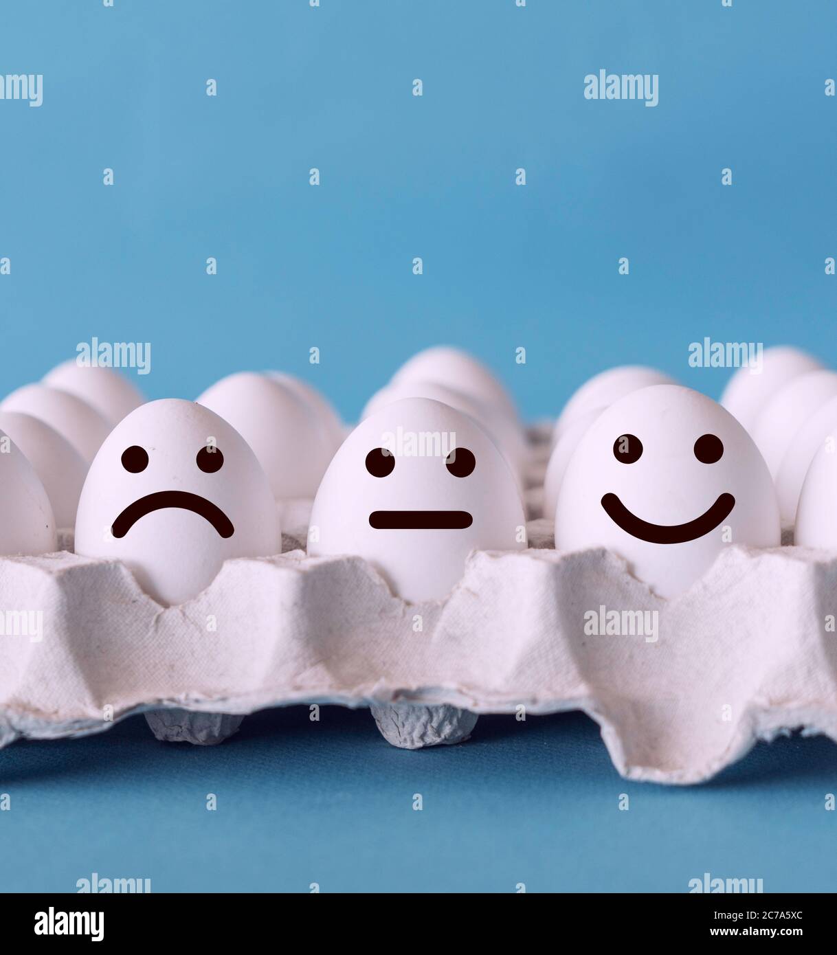 Konzepte zur Bewertung des Kundenservice und zur Zufriedenheitsumfrage. Unglückliche normale und glückliche Gesichter auf den Eiern mit blauem Hintergrund. Stockfoto