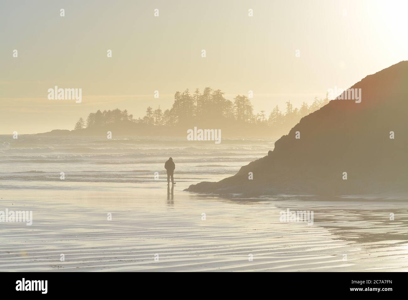 Wintersonnengang am Long Beach im Pacific Rim National Park Reserve mit Schooners Point im Hintergrund Stockfoto