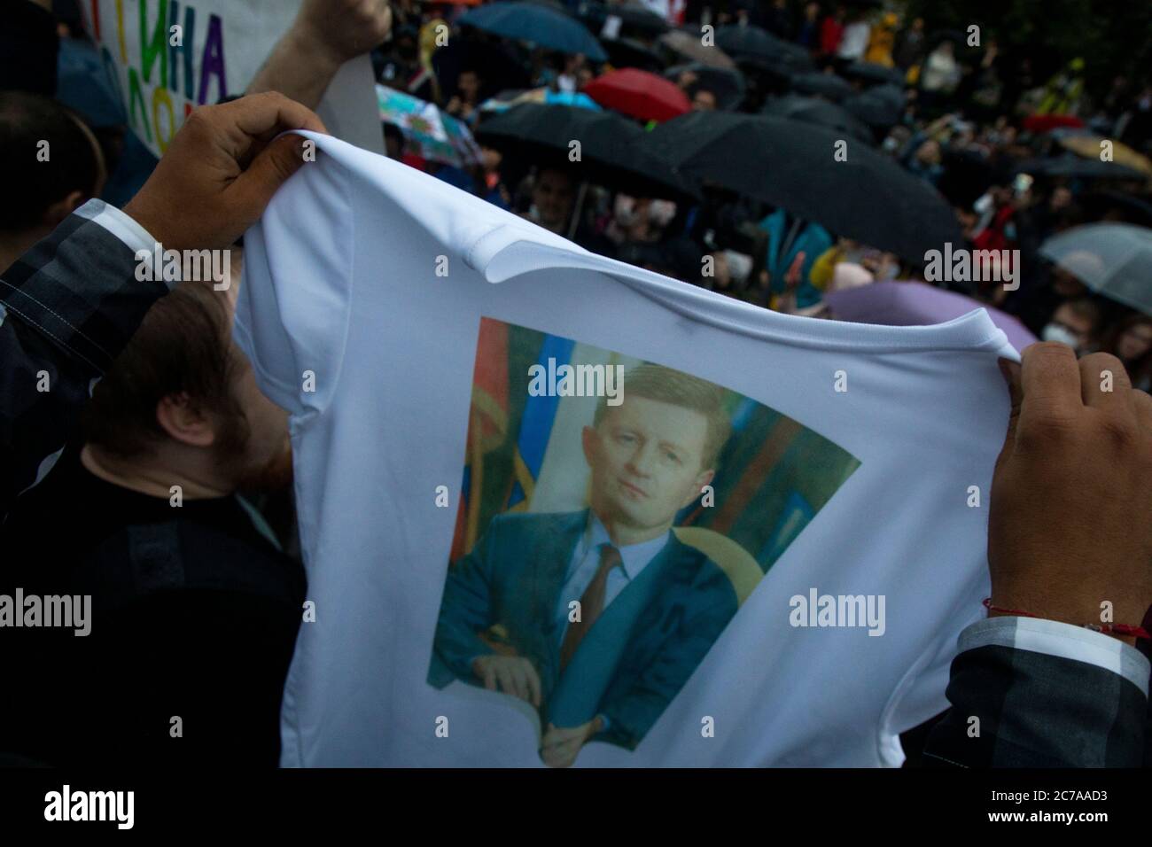 Moskau, Russland. 15. Juli 2020 Menschen nehmen an einem Protest gegen die Ergebnisse der landesweiten Abstimmung, die Reformen der russischen Verfassung genehmigt, in Moskau, Russland. Ein Mann hält Porrtait des Gouverneurs der Region Chabarowsk, Sergei Furgal, der letzte Woche wegen versuchten Mordes verhaftet wurde und die Tötung von zwei Geschäftsleuten im Jahr 2004-2005 anordnete Stockfoto