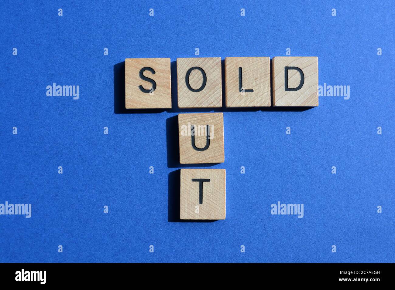 Ausverkauft, Wörter in Holzalphabetbuchstaben in Kreuzworträtsel-Form isoliert auf blauem Hintergrund Stockfoto
