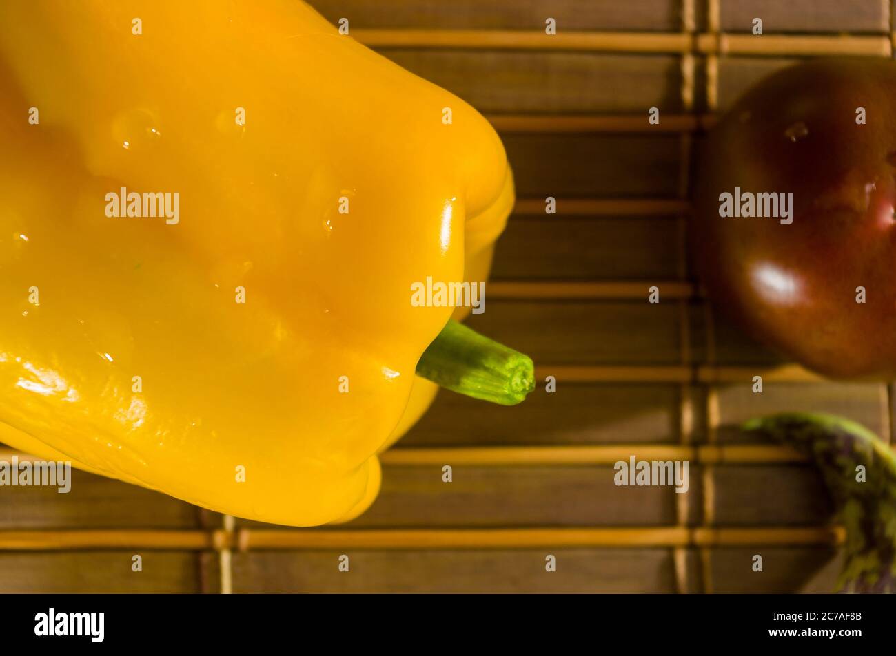 Stillleben im Herbst - Spargelbohnen, lila Basilikum, Paprika, gelbe und Schokoladentomaten auf Bambus-Matte Stockfoto